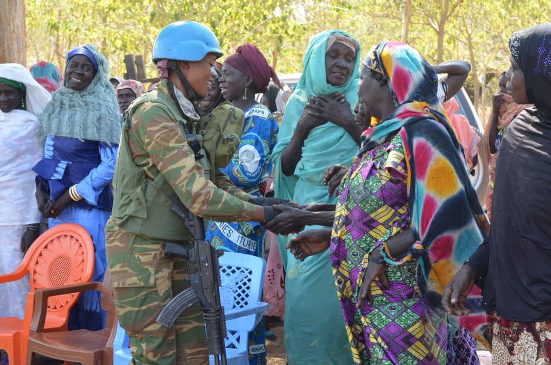 A woman peacekeeper shaking hands with a group of women in South Sudan