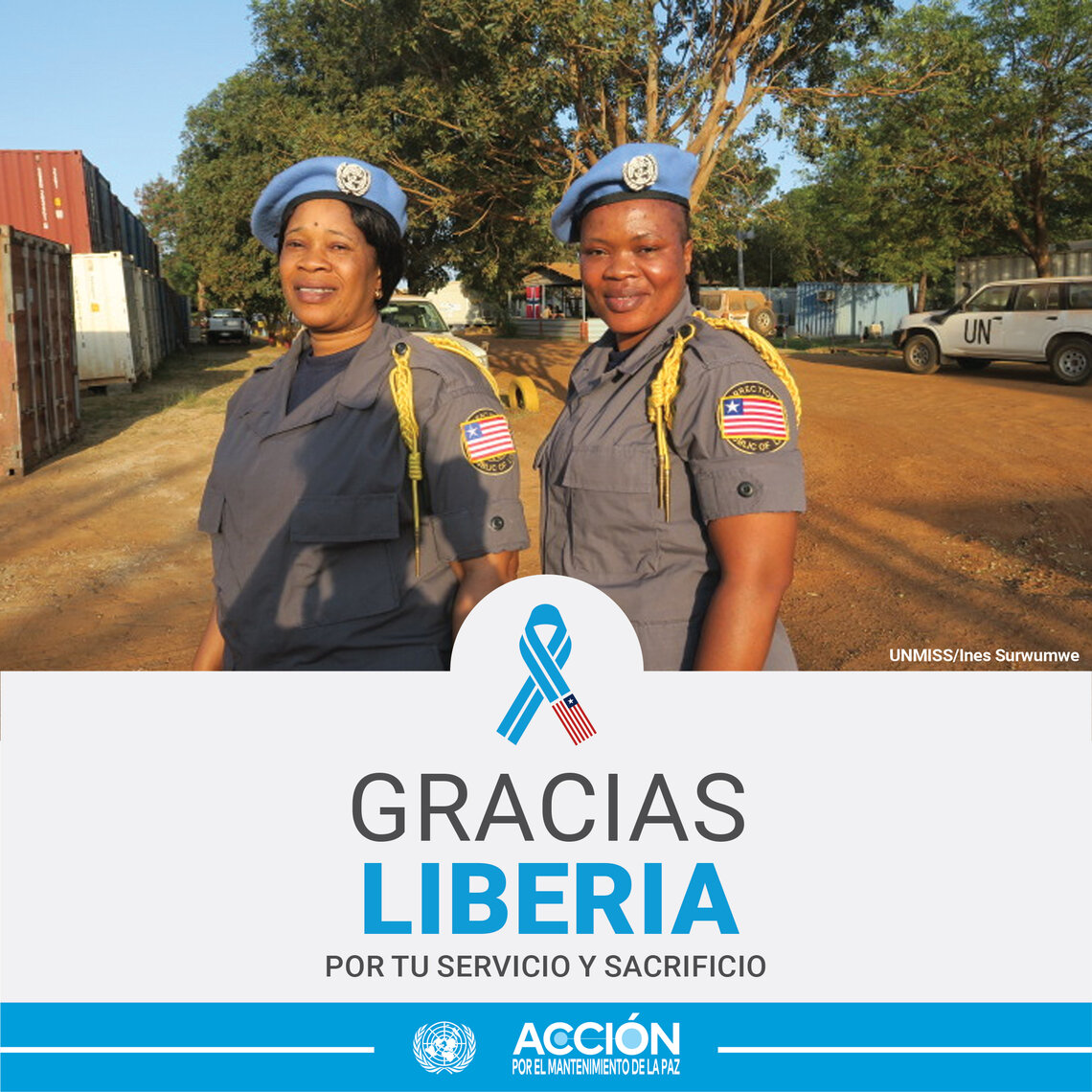 Dos mujeres cascos azules de Liberia posando para una foto. Al fondo a la derecha hay una coche de las Naciones Unidas. 