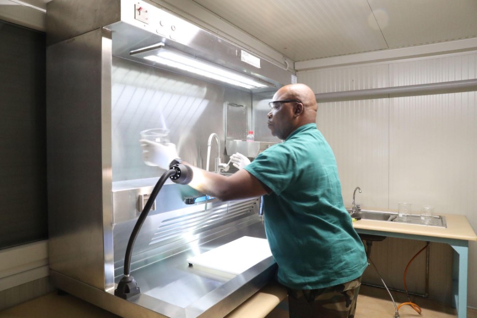 A medical officer sterilizes surgical tools inside the Light Mobile Surgical Module.