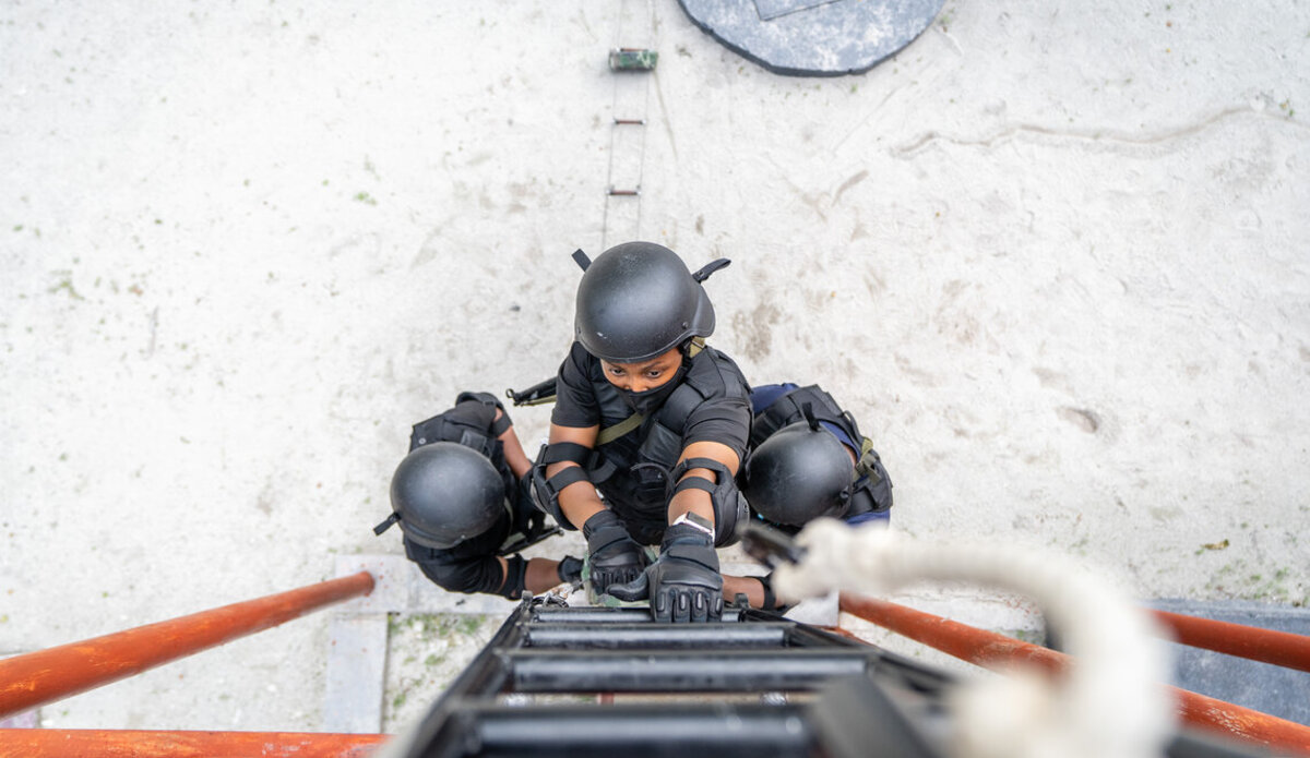 Women officers climb a ladder during a training on maritime law enforcement