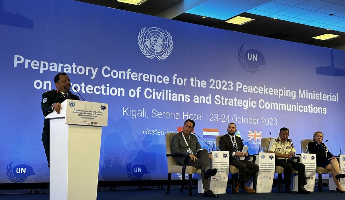 People on stage on the right side of the photo and speaker at podium on the left side.