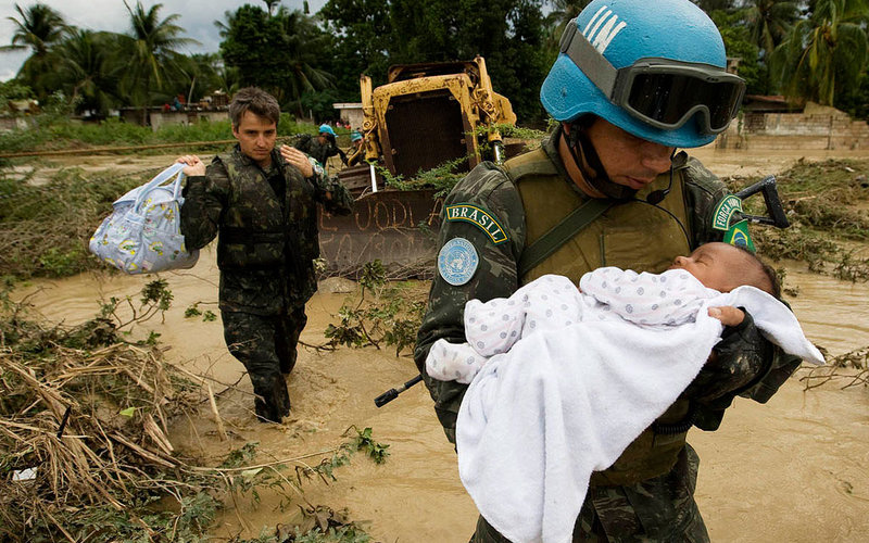 La MINUSTAH también trabajó para ayudar a los haitianos durante una serie de desastres naturales en los últimos 13 años, incluidas las fuertes lluvias de la tormenta tropical Noel en 2007, que dejaron a miles de personas sin hogar. Arriba, un Casco azul brasileño de la ONU rescata a un bebé y su familia de una casa inundada en Cite Soleil.