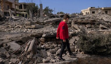 A young child walks amongst the ruins of houses in southern Lebanon.