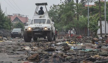 UN peacekeepers patrol Goma in the eastern DR Congo after the city is overrun by rebel forces. In the foreground, military uniforms and equipment have been abandoned on the road. 