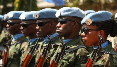 Photo of a line of peacekeepers, where only one is a woman. 