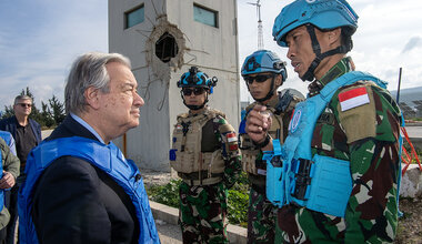 Secretary-General António Guterres (left) meeting with 3 Indonesian peacekeepers in uniform wearing blue helmets.