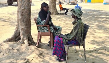 Atoch assise sous un arbre, écoutant des femmes qui ont subi des abus ou d'autres violations de leurs droits. Crédit photo : UNISFA