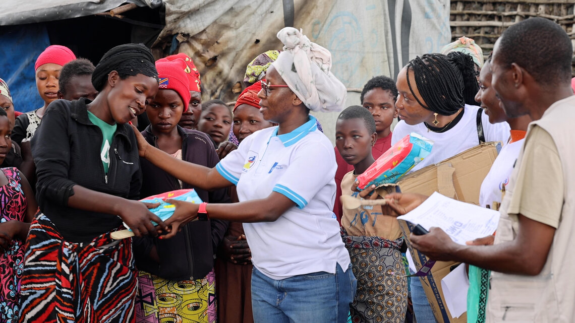 Anny distribue des serviettes hygiéniques et d’autres produits de première nécessité aux femmes et aux filles du camp de Kanyaruchinya, en République démocratique du Congo. Photo : Alain Wandimoyi/MONUSCO