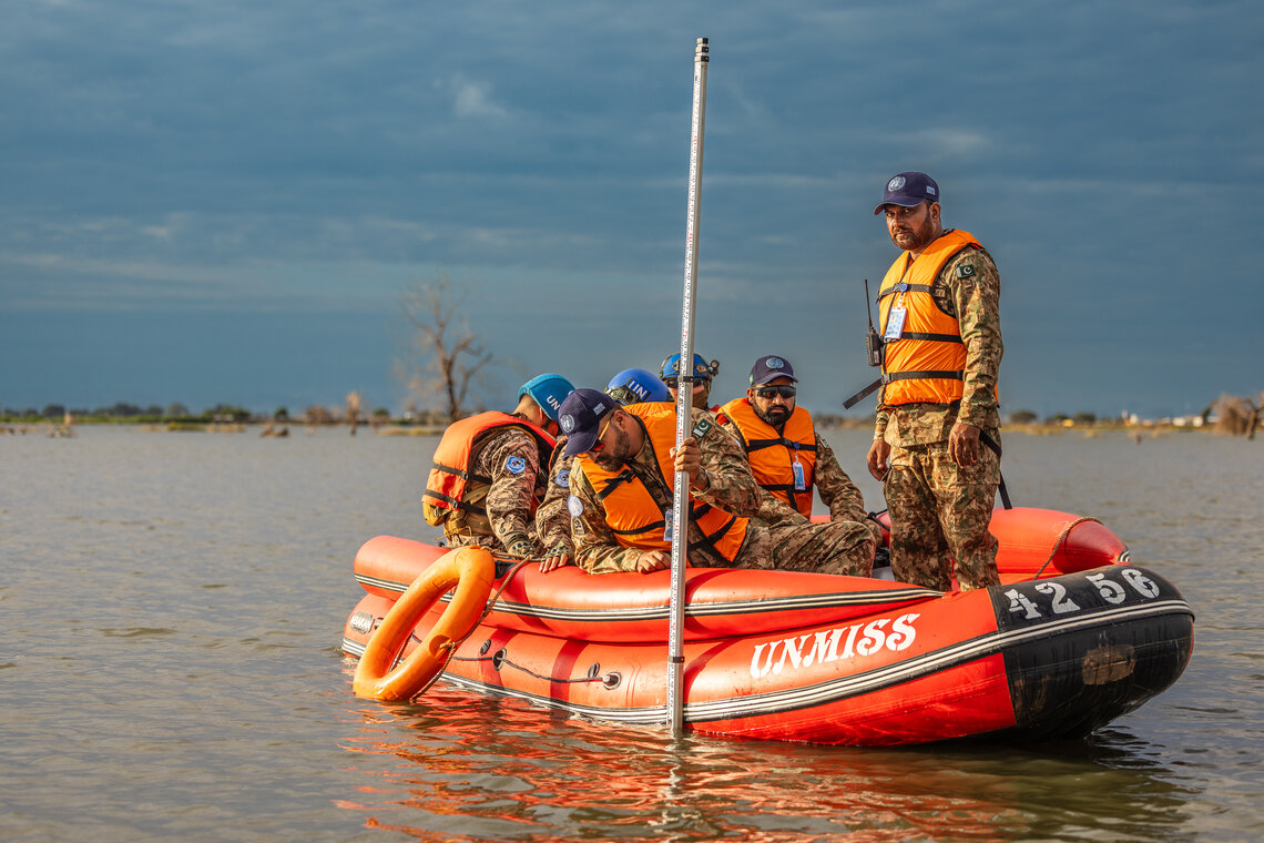 UNMISS peacekeepers in a boat assess floodwaters